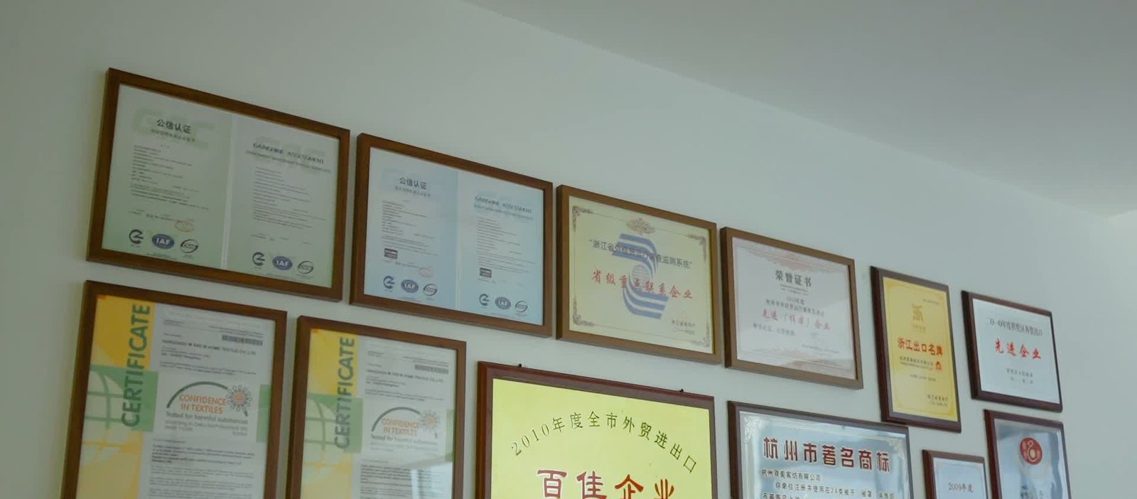 Certificate wall at the Hangzhou office — ISO 9001, ISO 14001, Oeko-Tex Standard 100, Hangzhou Famous Trademark